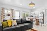 Open-concept space featuring tile flooring, white cabinetry, a built-in wall shelf, flush-mount ceiling lighting, and a dome pendant fixture