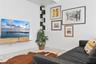 Wall-mounted light-wood floating shelf and black corner shelving unit, featuring white stone-finish tile flooring
