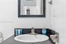 Bathroom vanity featuring a dark countertop, integrated white basin, metallic faucet, and a black-framed wall mirror