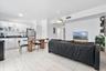 Kitchen featuring white flat-panel cabinetry, dark countertops, and large-format tile flooring