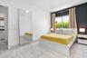 Neutral-toned tile flooring, large-format mirror with sleek framing, and an accent wall featuring a dark finish