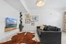 Interior space featuring tile flooring, a wall-mounted wood-finish media shelf, a built-in vertical corner shelving unit, and a dome-style pendant lig