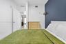 Bedroom featuring a charcoal-toned accent wall and white interior walls