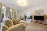 Living area featuring wood-finish flooring, floor-to-ceiling windows, and a multi-arm geometric ceiling fixture