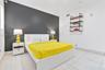 Charcoal accent wall with light-toned floor tiling and industrial-style mounted wooden shelving featuring metal pipe brackets