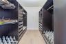 Custom closet featuring dark wood-finish cabinetry, built-in drawer units, integrated wire shelving, and slide-out shoe storage racks