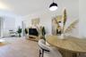 Neutral-toned interior featuring wood-finish flooring, white walls, and a contemporary black dome pendant light fixture