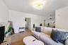 Neutral-toned wood-finish flooring, multi-arm gold-tone chandelier, and recessed ceiling lighting