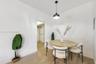 Neutral interior featuring wood-finish flooring, crisp white walls, and a contemporary matte black pendant light fixture