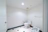 Restroom featuring a dual-piece toilet, porcelain bidet, stone-finish tile flooring with inlaid accents, and a coordinating stone baseboard