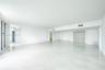 Open-concept interior featuring polished tile flooring, smooth ceilings, recessed lighting, and double-door closet entry