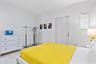 Neutral walls, white tile flooring, and a single window featuring horizontal blinds
