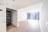 Living area featuring light wood-finish flooring, floor-to-ceiling sliding glass doors, built-in closet organization system, and ocean horizon backdro