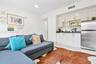 Kitchenette featuring white cabinetry, black countertops, and stainless steel refrigerator