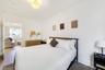 Neutral interior featuring light-toned wood-finish flooring, crisp white wall finishes, and a contemporary semi-flush mount ceiling fixture