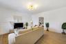 Spacious interior featuring wood-finish flooring, neutral wall paint, and a multi-arm brass finish light fixture