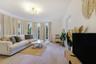 Living space featuring wood-finish flooring, a semi-circular bay window, and a multi-arm geometric ceiling light fixture