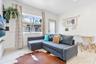 Living area featuring large-format tile flooring, recessed lighting, and a single-pane window with white trim