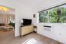 Wood-finish flooring, white walls, and a large window featuring natural exterior greenery