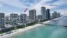 Aerial perspective of Sunny Isles coastal high-rise building with direct oceanfront proximity