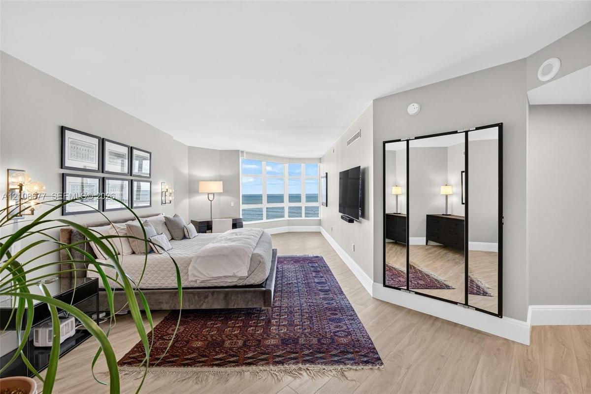 Wood look plank porcelain flooring, floor-to-ceiling bay windows, and a multi-panel mirror dressing area. This is said to be the only unit in the buil