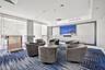 Spacious community room, free to use, featuring floor-to-ceiling windows, updated flooring and furniture