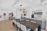 Open-concept dining space space featuring wood look plank porcelain flooring, a coffered ceiling with recessed lighting, minimalist flat-panel cabinet