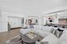 Open floor plan featuring wood look plank porcelain flooring, recessed lighting, double-door entry / foyer, and view toward the kitchen and stone wall