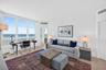 Expansive windows featuring water views, light-toned wood look plank porcelain flooring, and double layered (light filtering and room darkening) remot