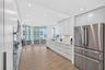 Contemporary updated top of the line kitchen featuring flat-panel white cabinets, stainless Bosch appliances (Miele dishwasher), integrated wall ovens