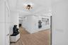 Widened hallway with primary bedroom straight down the hall, second bedroom next to it, plus gorgeous modern kitchen featuring white flat-panel cabine