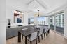 Floor-to-ceiling impact windows, recessed architectural ceiling detail with integrated lighting, wood look plank porcelain flooring, custom cabinets w