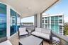 Covered balcony featuring wood look plank porcelain flooring, floor-to-ceiling glass paneling, and a metal railing. Additional protection for your fur