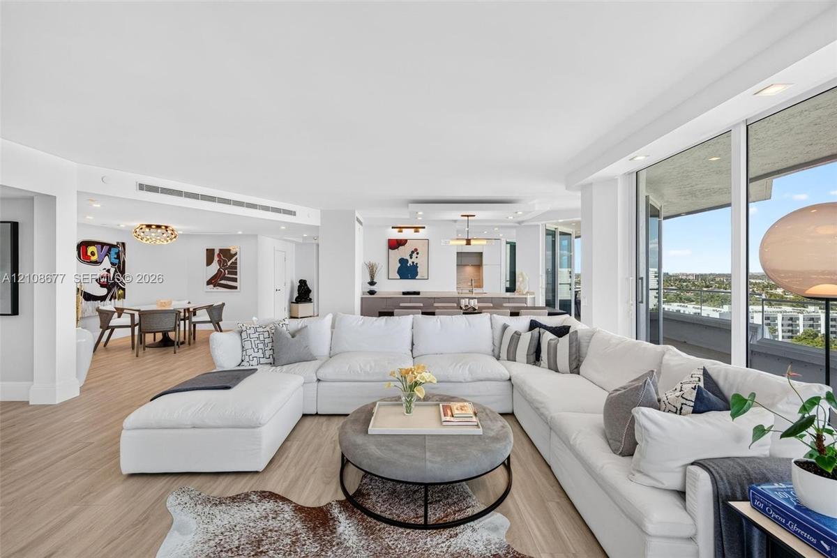 Open-concept floor plan featuring wood look plank porcelain flooring, floor-to-ceiling glass doors, recessed lighting, and a built in buffet behind th