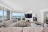 Floor-to-ceiling windows, wood look plank porcelain flooring, recessed lighting, and a private covered balcony. TV wall was expanded to accommodate a 