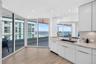 Kitchen featuring flat-panel white cabinets, stone counters, undermount sink with a beautiful gooseneck faucet, wood look plank porcelain flooring, an