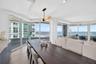 Floor-to-ceiling impact windows, wide-plank tile flooring, recessed lighting, contemporary linear light fixture, and wrap-around exterior balcony with
