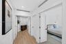Hallway toward primary bedroom w/ double door entry, w/ wood look plank porcelain flooring, recessed lighting, and solid-core doors with matte black h