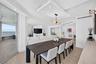 Open-concept interior featuring wood look plank porcelain flooring, recessed lighting, a custom architectural ceiling, a modern linear chandelier, and