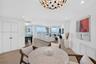 Open-concept informal dining or office space featuring wood look plank porcelain flooring, views toward the living room area, floor-to-ceiling windows