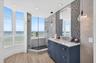 Full Bathroom off guest bedroom / den featuring a wood look plank porcelain floor, navy blue vanity with a stone countertop, glass-enclosed shower wit