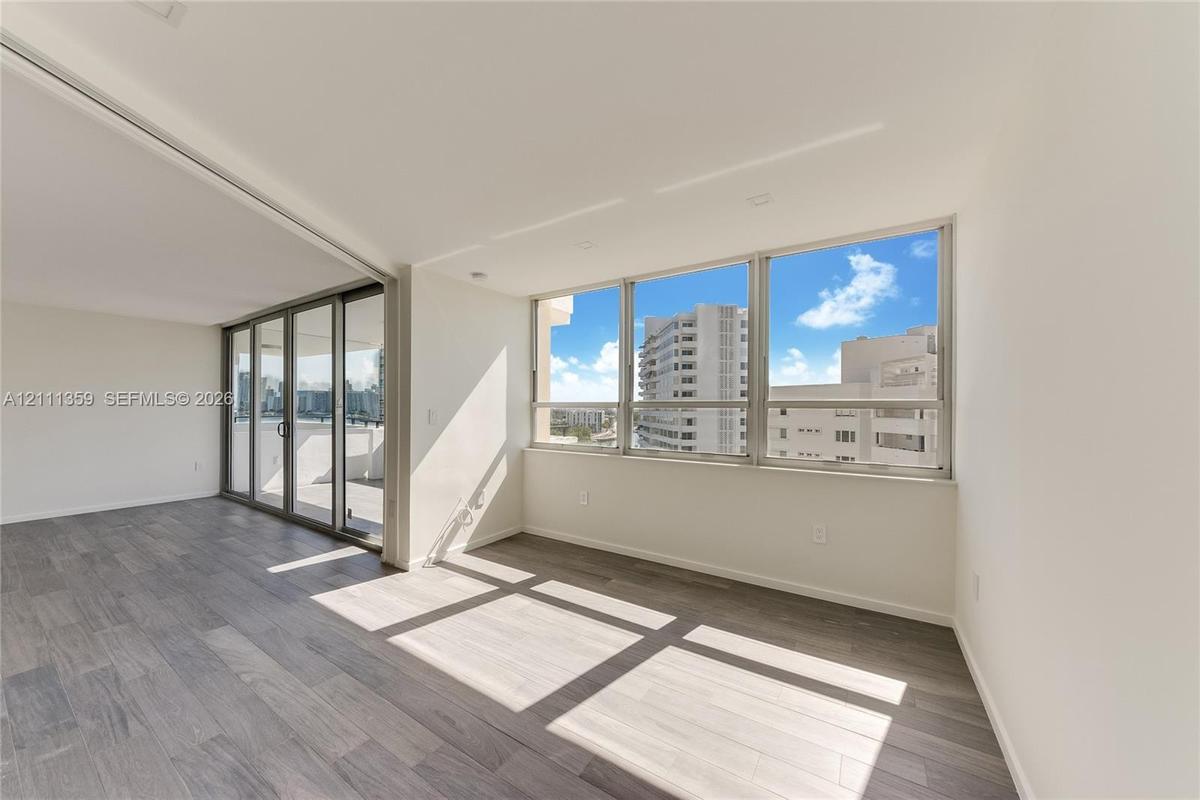 Open-concept interior featuring wood-finish flooring, floor-to-ceiling windows, recessed lighting, and sliding glass doors