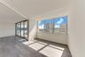 Open-concept interior featuring wood-finish flooring, floor-to-ceiling windows, recessed lighting, and sliding glass doors