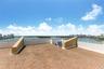 Expansive rooftop terrace featuring terracotta-style brick pavers, integrated solid-surface perimeter walls, and metal railings