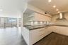 Modern kitchen featuring high-gloss white cabinetry, solid-surface countertops, stainless steel range hood, recessed lighting, and wood-finish floorin