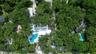 Aerial perspective of a sprawling property featuring mature hardwood canopy, an inground pool with hardscaped surround, and expansive grounds