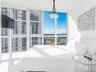 Floor-to-ceiling windows, polished flooring, and a multi-bulb hanging pendant light fixture