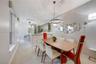 Light-toned wood-finish flooring, circular LED chandelier, textured wall covering, recessed ceiling lighting, and quartz-topped island with stone-fini
