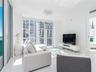 Floor-to-ceiling windows, high-gloss white flooring, white walls, and a decorative contemporary ceiling fixture