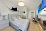 Room featuring wood-finish flooring, recessed lighting, a modern pendant light fixture, and floor-to-ceiling mirrored closet doors
